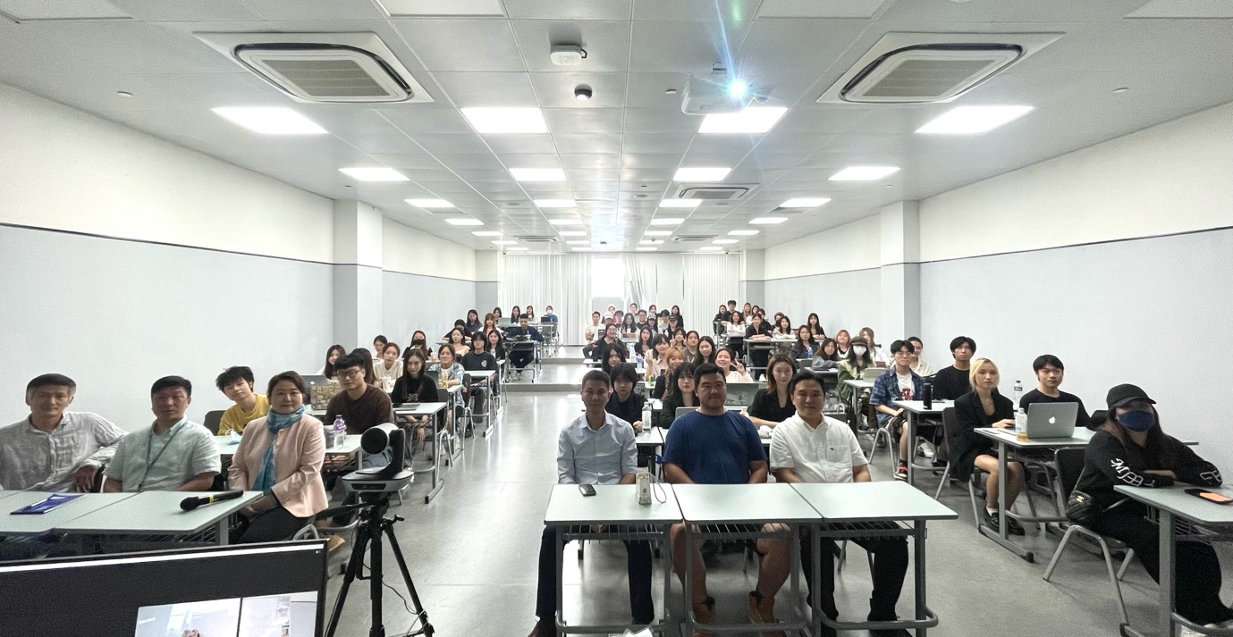 A group of people sitting at desks in a classroom

Description automatically generated